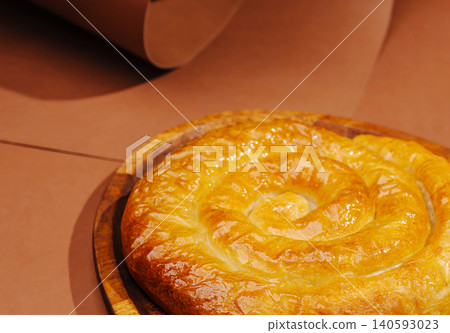 Traditional spiral banitsa pie on wooden platter Traditional spiral banitsa pie on wooden platter 140593023