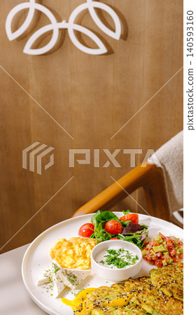 Zucchini fritters breakfast with scrambled eggs cheese Zucchini fritters breakfast with scrambled eggs cheese 140593160