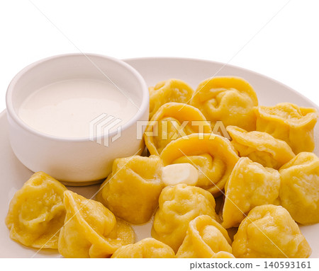 Boiled yellow dumplings pelmeni with sour cream Boiled yellow dumplings pelmeni with sour cream 140593161