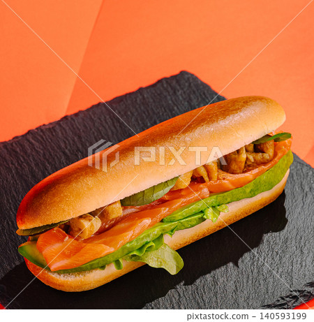 Delicious smoked salmon sub on a black slate board Delicious smoked salmon sub on a black slate board 140593199