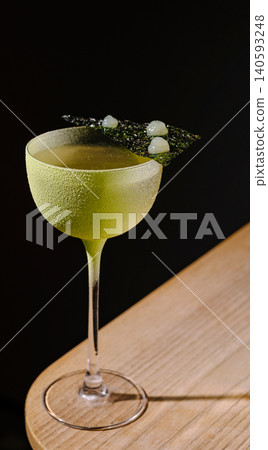 Green gin cocktail with nori seaweed garnish 140593248