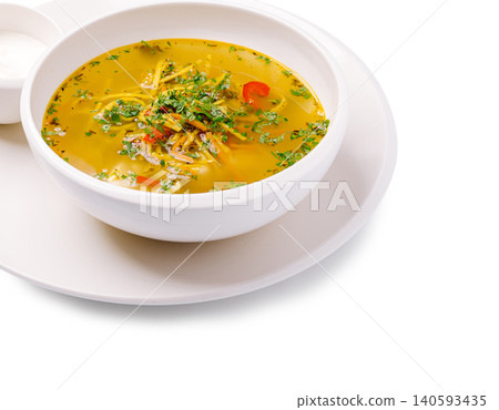 Delicious soup served in a white bowl with fresh herbs and vegetables Delicious soup served in a white bowl with fresh herbs and vegetables 140593435