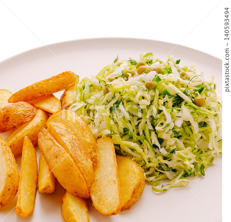 Healthy dish with potato wedges and fresh cabbage salad on white plate Healthy dish with potato wedges and fresh cabbage salad on white plate 140593494