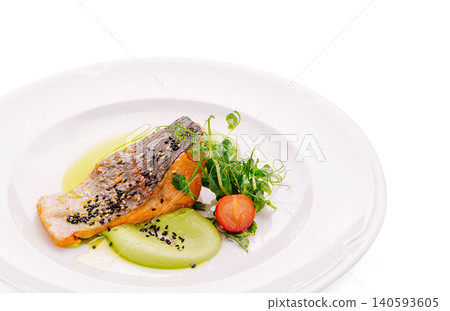 Delicious salmon with fresh salad on a white plate in a restaurant setting Delicious salmon with fresh salad on a white plate in a restaurant setting 140593605
