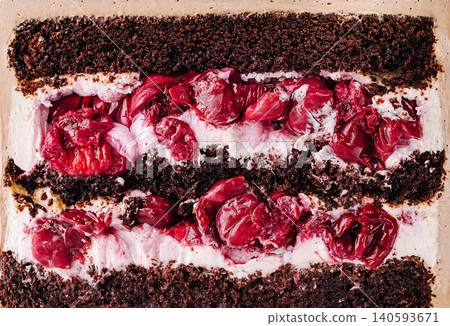 Chocolate cake layered with cherries and cream in dessert dish 140593671
