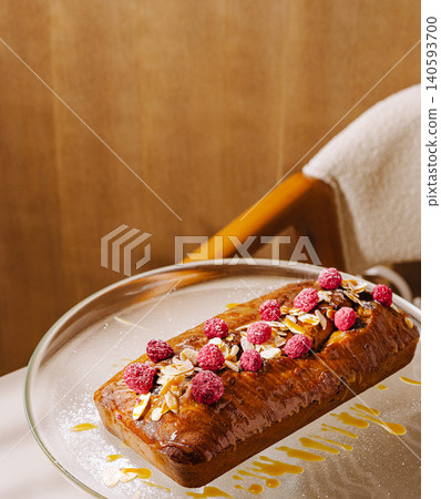 Delicious loaf cake with berries and nuts on a glass plate at a cafe Delicious loaf cake with berries and nuts on a glass plate at a cafe 140593700