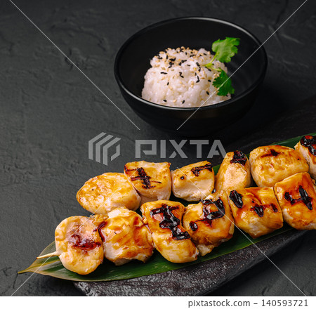 Grilled chicken skewers served with rice on a dark surface 140593721