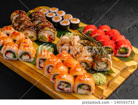 Various types of sushi arranged on a wooden board for a meal 140593733
