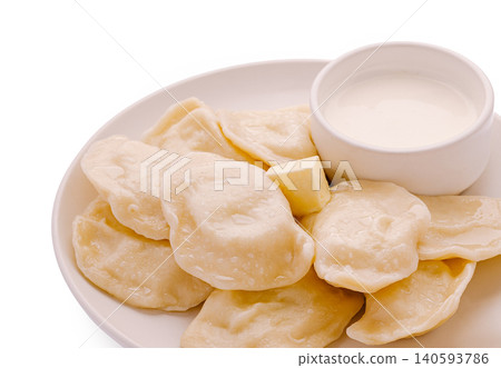 Homemade dumplings served with cream on a white plate Homemade dumplings served with cream on a white plate 140593786