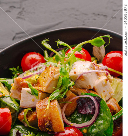 Fresh salad with grilled chicken and cherry tomatoes served in a bowl 140593978