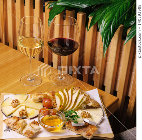 Enjoying wine and cheese at a cozy table with fresh fruit and honey 140593988