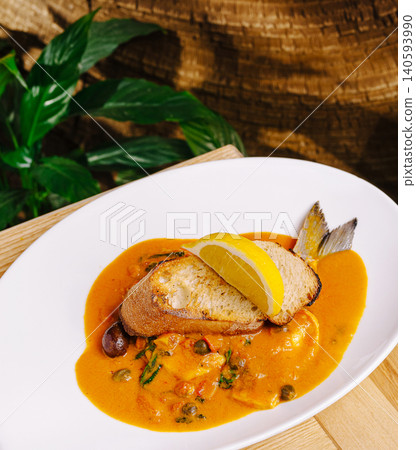 Fresh fish dish served with sauce and bread at a restaurant in the afternoon Fresh fish dish served with sauce and bread at a restaurant in the afternoon 140593990