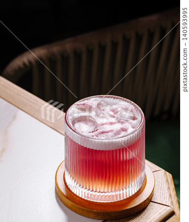 Refreshing drink served in a glass on a wooden table inside a bar Refreshing drink served in a glass on a wooden table inside a bar 140593995