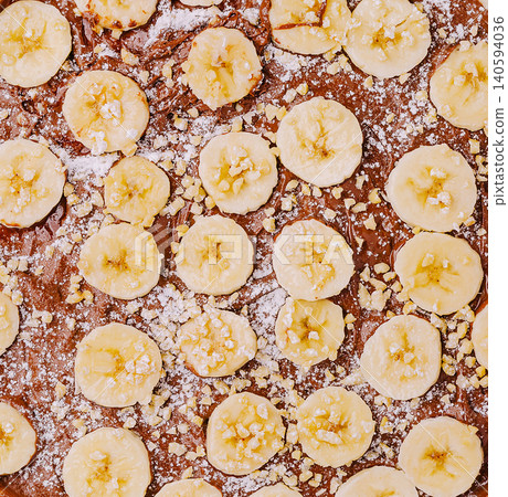 Dessert with bananas on chocolate cake covered with crushed nuts Dessert with bananas on chocolate cake covered with crushed nuts 140594036