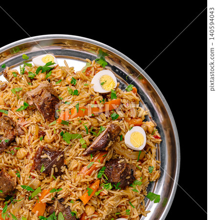 Delicious rice dish with meat, eggs, and vegetables served in a silver plate Delicious rice dish with meat, eggs, and vegetables served in a silver plate 140594043
