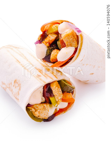 Two wraps filled with vegetables and chicken on a white background Two wraps filled with vegetables and chicken on a white background 140594076
