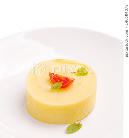 Mashed potato dish served with tomato and herbs in a simple setting Mashed potato dish served with tomato and herbs in a simple setting 140594078