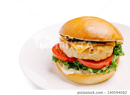 Burger with chicken patty, cheese, lettuce, tomato, and mayonnaise on bun Burger with chicken patty, cheese, lettuce, tomato, and mayonnaise on bun 140594082