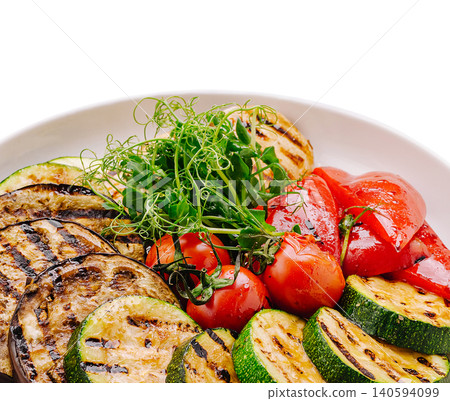 Grilled vegetables served on a white plate at a dining table Grilled vegetables served on a white plate at a dining table 140594099