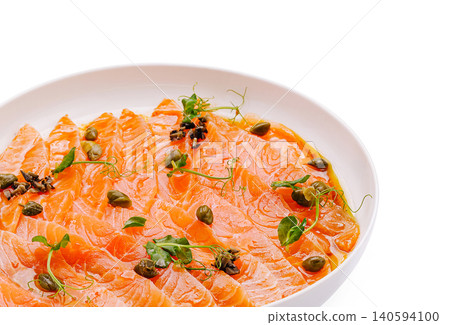 Sliced salmon served with capers and herbs on a white plate Sliced salmon served with capers and herbs on a white plate 140594100