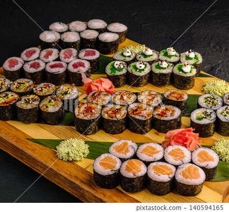 Various sushi rolls arranged on a wooden board for a meal setting Various sushi rolls arranged on a wooden board for a meal setting 140594165