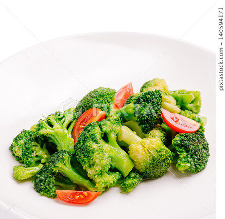 Fresh broccoli and tomato salad on a white plate for lunch Fresh broccoli and tomato salad on a white plate for lunch 140594171