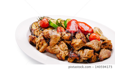 Grilled meat and vegetables served on white plate at outdoor barbecue Grilled meat and vegetables served on white plate at outdoor barbecue 140594173