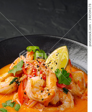 Shrimp dish with lime and cilantro served in black bowl on dark table Shrimp dish with lime and cilantro served in black bowl on dark table 140594178