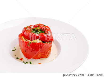 Stuffed red pepper with herbs served on a white plate in a kitchen setting Stuffed red pepper with herbs served on a white plate in a kitchen setting 140594206