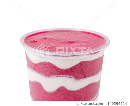 Delicious smoothie served in a clear cup with layers of red and white 140594224