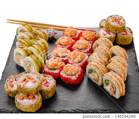 Different types of sushi arranged on a black platter served with chopsticks Different types of sushi arranged on a black platter served with chopsticks 140594260