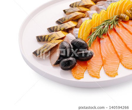 Seafood platter with smoked fish and olives served on a round white plate 140594266
