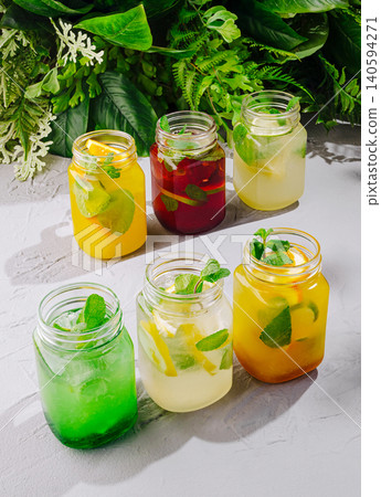 Colorful drinks in jars with fresh ingredients on a gray surface 140594271