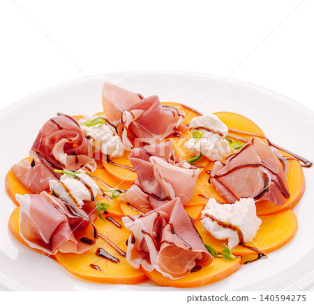 Fresh dish with prosciutto and fruit served on a white plate at a restaurant Fresh dish with prosciutto and fruit served on a white plate at a restaurant 140594275