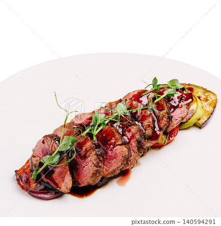 Cooked meat served on a plate with garnishes and sauce Cooked meat served on a plate with garnishes and sauce 140594291