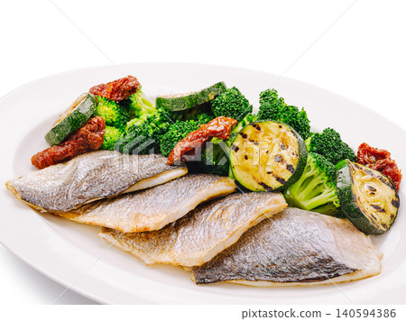 Grilled fish with broccoli and zucchini served on a plate Grilled fish with broccoli and zucchini served on a plate 140594386