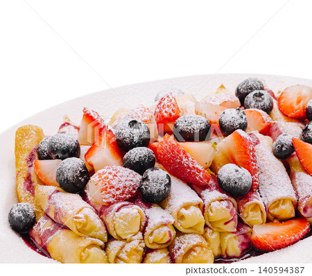 Fresh crepes filled with berries and topped with powdered sugar at breakfast Fresh crepes filled with berries and topped with powdered sugar at breakfast 140594387