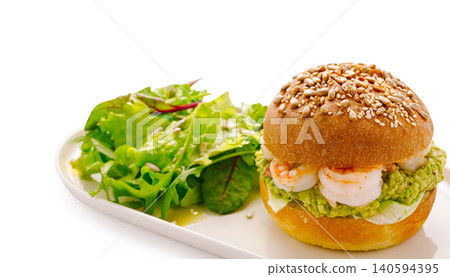 Shrimp sandwich with sesame seed bun and salad on a plate Shrimp sandwich with sesame seed bun and salad on a plate 140594395