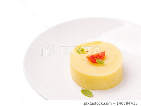 Mashed potato dish served on a white plate with tomato and herbs Mashed potato dish served on a white plate with tomato and herbs 140594415