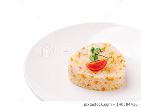 Dish of cooked rice shaped in a heart with tomato on a white plate Dish of cooked rice shaped in a heart with tomato on a white plate 140594416
