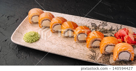 Sushi served on a plate with wasabi and ginger on a dark background 140594427