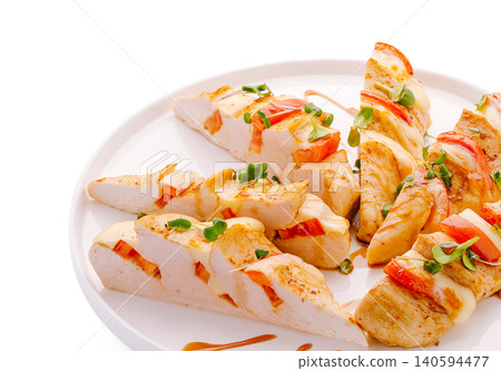 Grilled chicken breast slices served on white plate with sauce and garnish 140594477