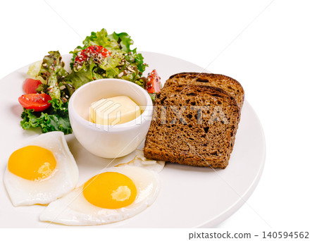 Breakfast meal with eggs, salad, bread, and butter on a white plate Breakfast meal with eggs, salad, bread, and butter on a white plate 140594562