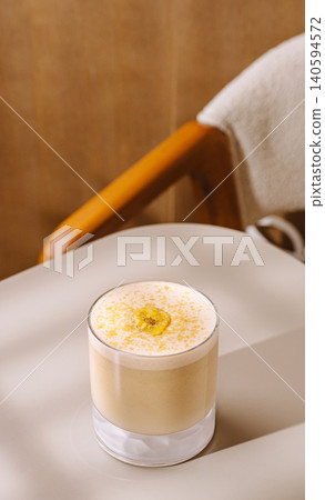 Warm drink served in a glass on a table near a chair in a cafe setting Warm drink served in a glass on a table near a chair in a cafe setting 140594572