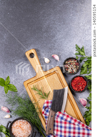 Cutting board with fresh herbs, spices and cleaver Cutting board with fresh herbs, spices and cleaver 140595154