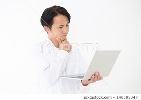 一位身穿白襯衫的中年男子,在白色背景前若有所思地看著他的筆記型電腦。 一位身穿白襯衫的中年男子,在白色背景前若有所思地看著他的筆記型電腦。 140595347