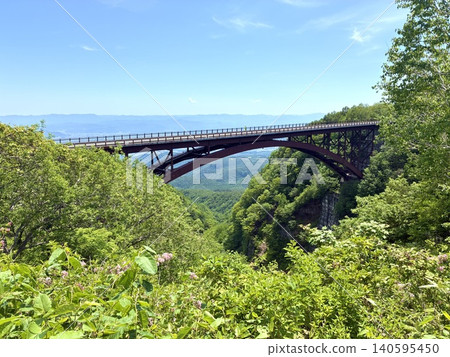 A scenic drive in early summer: A massive bridge spanning a valley in the rich natural beauty of the area. A scenic drive in early summer: A massive bridge spanning a valley in the rich natural beauty of the area. 140595450
