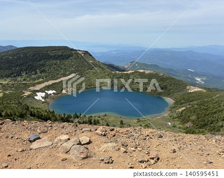 From the mountaintop, you can look down on the beautiful emerald-blue Goshikinuma lake and the rugged caldera. From the mountaintop, you can look down on the beautiful emerald-blue Goshikinuma lake and the rugged caldera. 140595451