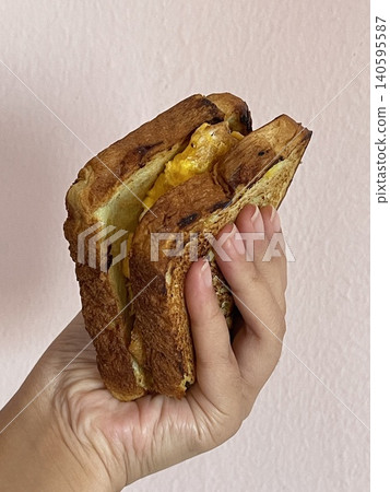 Hand Holding Pandan Coconut Toast Sandwich with Fried Egg 140595587