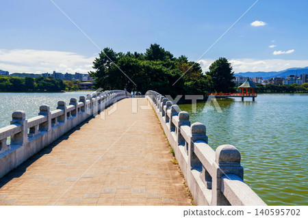 Bridge to hexagonal red pavilion island from Ohori lake park, Fukuoka 140595702